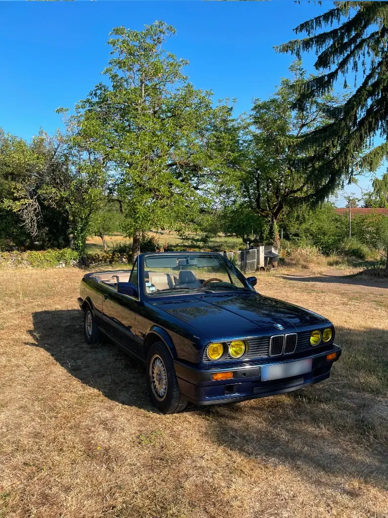 BMW E30 318i Cabriolet bleu décapoté de trois-quarts avant