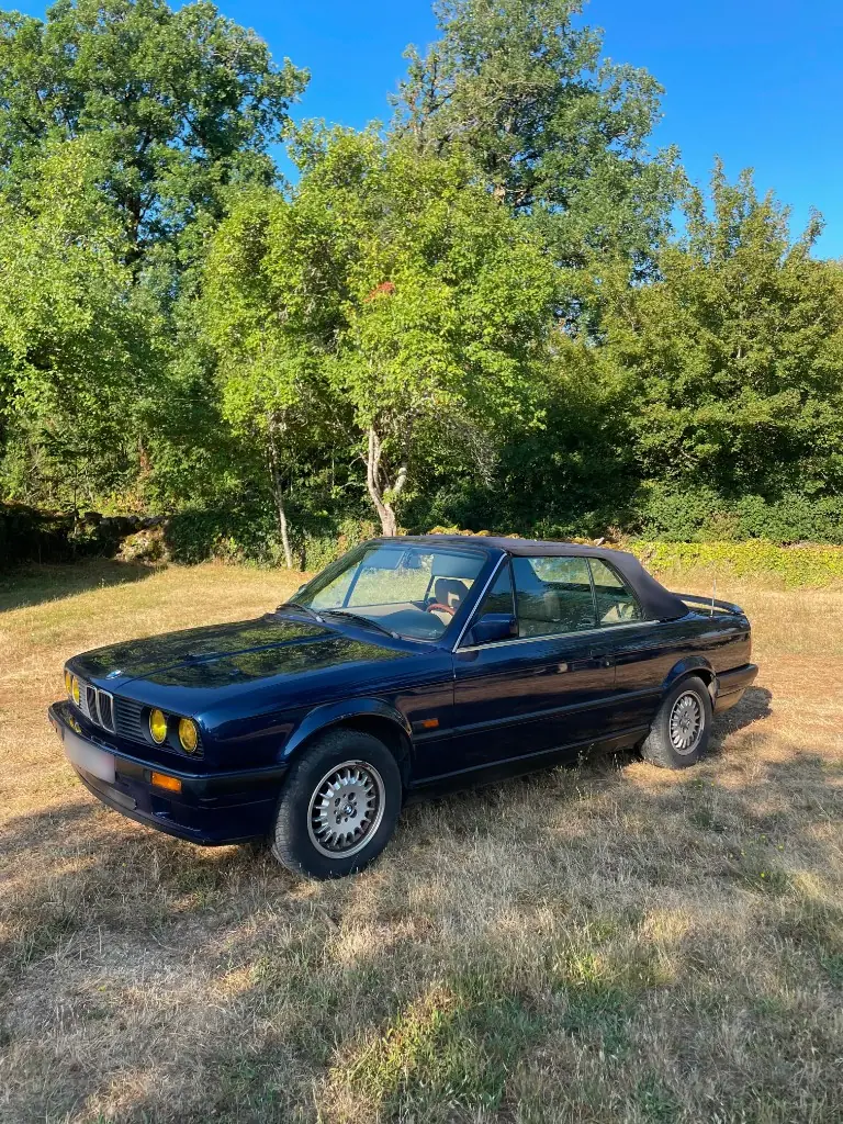 BMW E30 318i Cabriolet bleu trois-quarts avant capote fermée